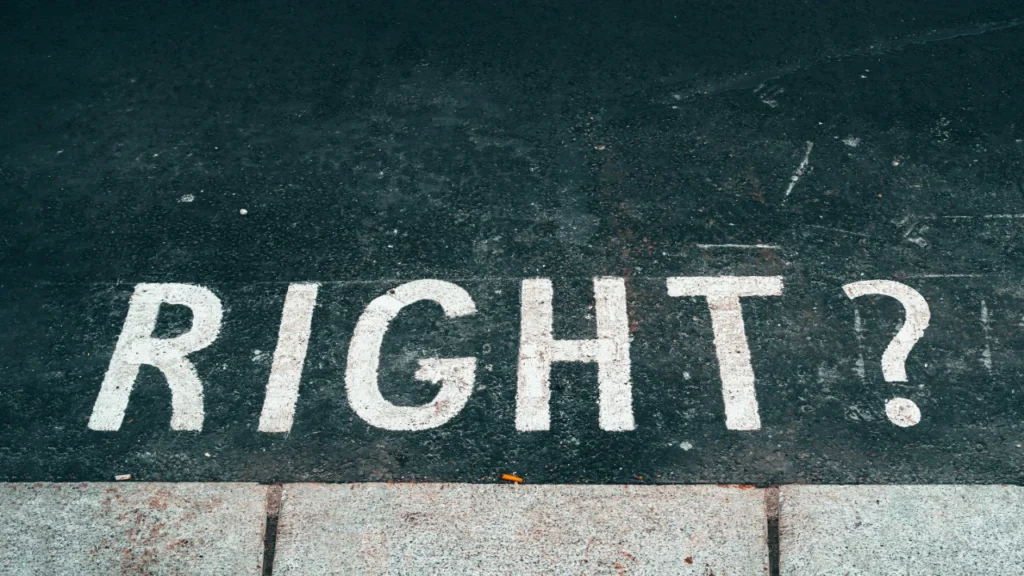 The word RIGHT with a question mark painted on dark asphalt, symbolizing the search for fairness in a Group Decision.