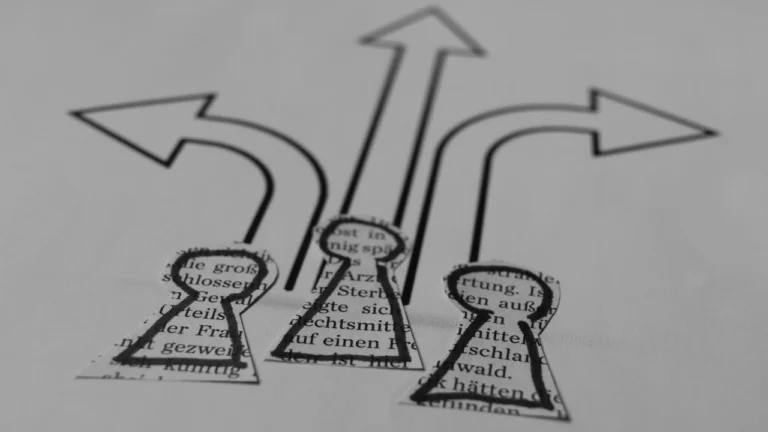 Three paper pawn cutouts facing different drawn directional arrows to represent multi-option scenarios in a Group Decision.