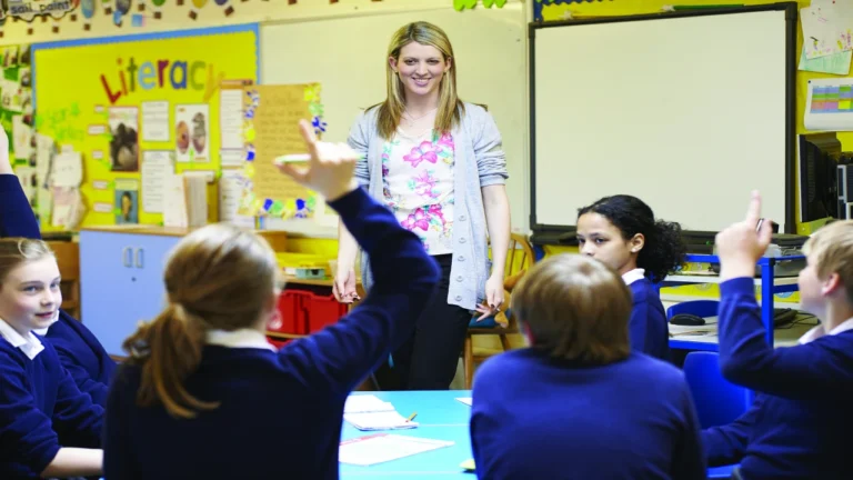 Students raising hands during a classroom discussion to illustrate fair student participation strategies