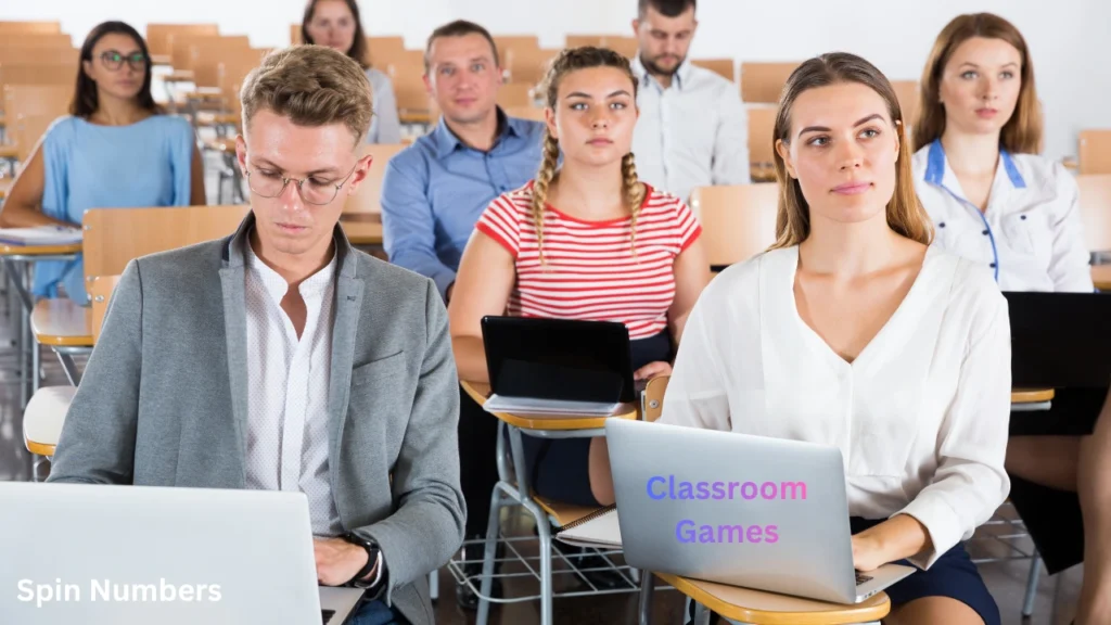 Group of mature students sitting in desks using laptops and tablets to participate in tech-driven classroom games.